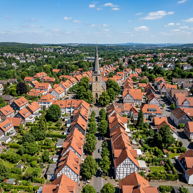 Drohnenaufnahme einer typischen deutschen Kleinstadt mit Fachwerkhäusern und Kirchturm